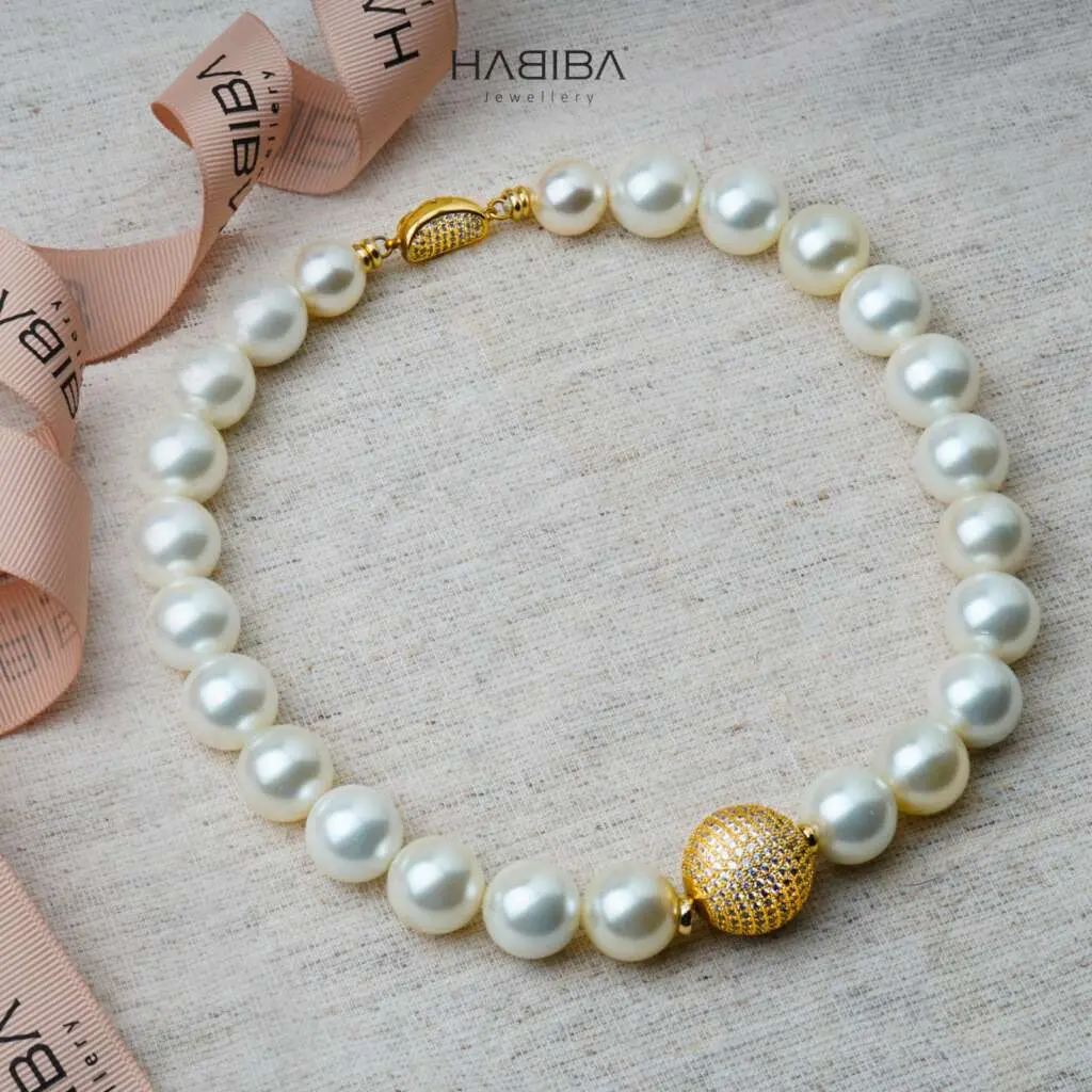 Collier en perles blanches et boule en doré